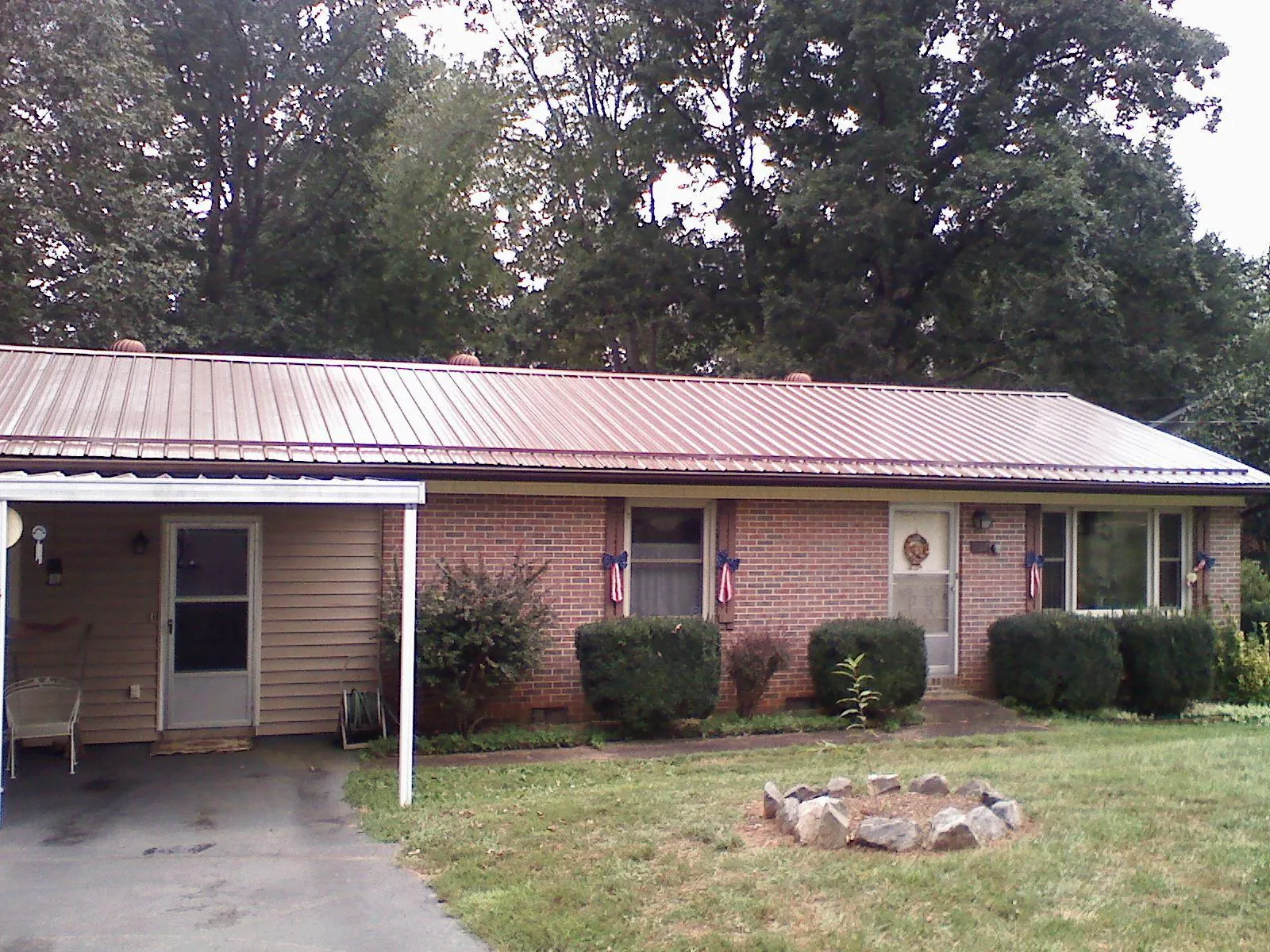 Bronze metal roof and carport on a brick ranch home — Roof Repair work by our crew in Putnam